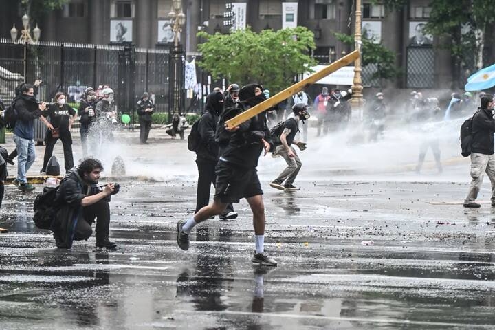 Un manifestante lanza un palo contra la policía.
