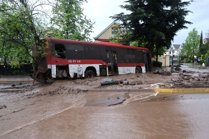 Uno de los micros arrastrados por el barro y el agua en Chile. Foto EFE