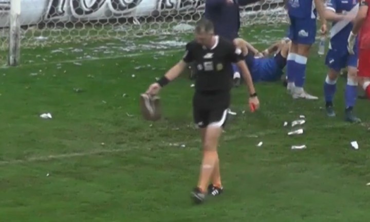 Fernando Rekers saca dos zapatillas que le tiraron desde la tribuna.